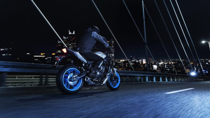 Zadnji pogled na Yamaha MT-07 2025 med vožnjo, osvetljena LED zadnja luč in široka zadnja pnevmatika.