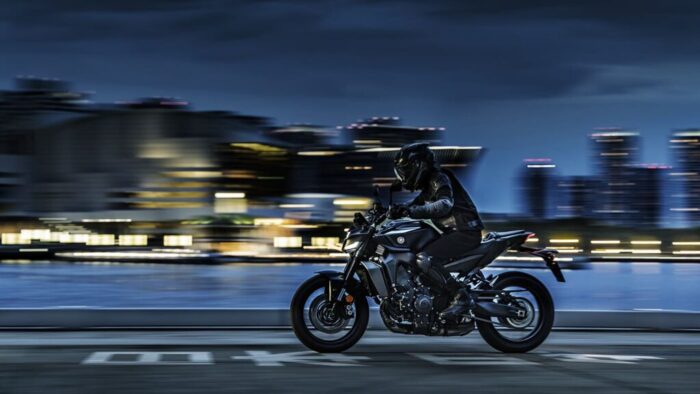 Yamaha MT-09 Y-AMT 2025 med nočno vožnjo skozi urbano okolje, LED osvetlitev in dinamična silhueta modela.