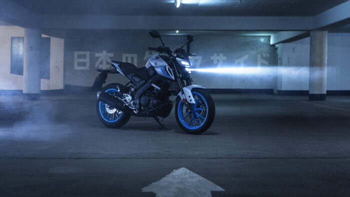 Yamaha MT-125 2026 parkirana v podzemni garaži z osvetljenim LED žarometom in modrimi platišči v barvi Ice Storm.