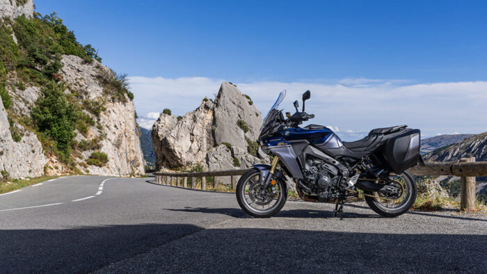 Yamaha Tracer 9 GT+ Y-AMT 2025 ob skalni cesti – dinamična silhueta sport touring motocikla