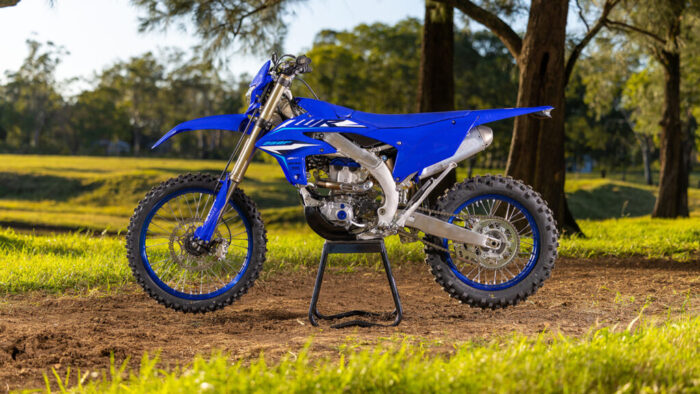 Yamaha WR250F 2026 na stojalu – stranski profil v barvi Icon Blue na odprtem terenu