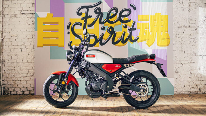 Yamaha XSR125 Legend White parkirana v urbanem okolju, brezčasna oblika z okroglim žarometom in klasičnim rezervoarjem