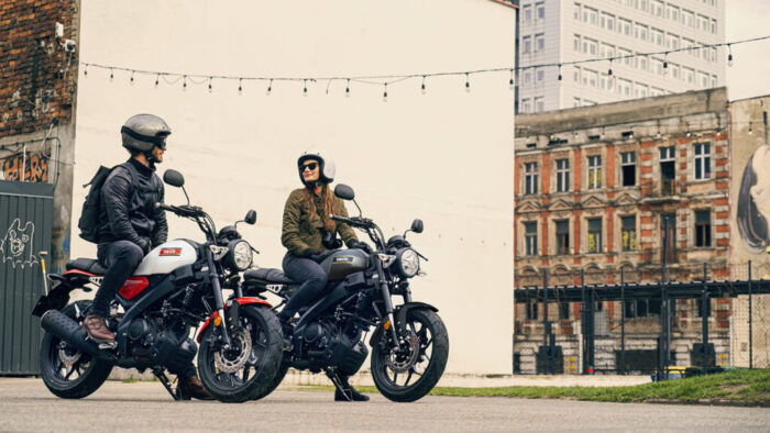 Dva motocikla Yamaha XSR125 v barvi Legend White med mestno vožnjo, retro slog in sodobna tehnologija za mlade voznike