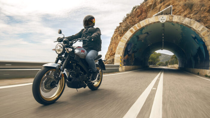 Yamaha XSR125 Legacy v vožnji skozi predor, heritage dizajn v kombinaciji srebrnega rezervoarja in črnega okvirja