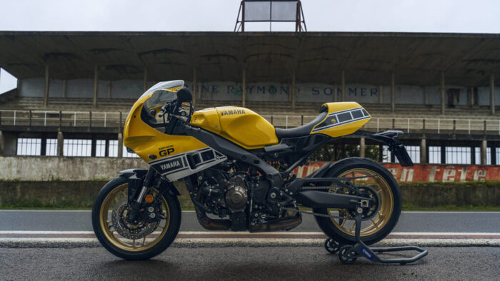 Yamaha XSR900 GP 2026 stranski profil na paddock stojalu – športni retro motocikel z 890-kubičnim CP3 agregatom in zlatimi platišči.