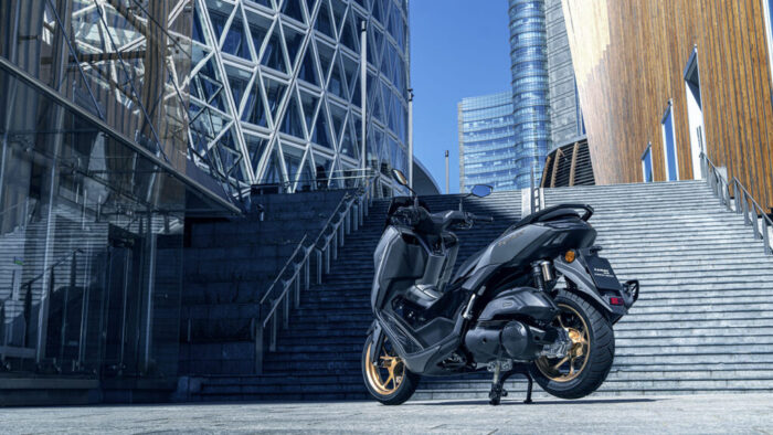 Zadnji pogled na NMAX 155 Tech MAX poudarja kompaktno športno silhueto in prepoznavno svetlobno podobo.