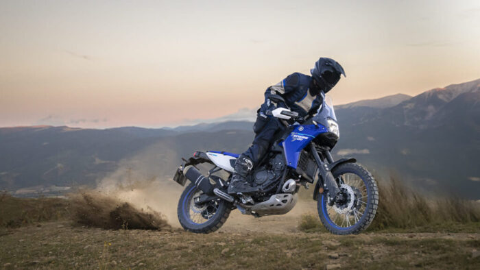 Yamaha Ténéré 700 med dinamično vožnjo po makadamski cesti v gorskem okolju