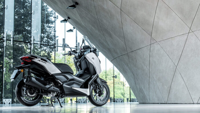 Tričetrtinski zadnji pogled na Yamaha XMAX 300 Tech MAX+ – eleganten zadek z LED lučmi in športnim izpuhom poudarja premium značaj modela.