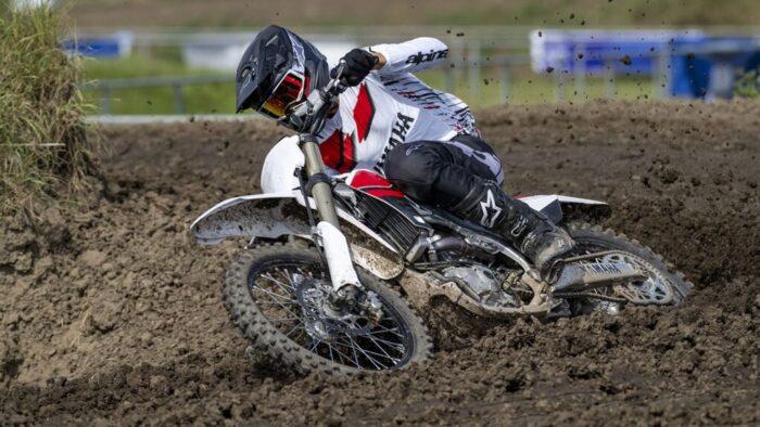 Yamaha YZ450F 70th Anniversary 2026 v globokem blatnem ovinku, prikaz oprijema in stabilnosti na zahtevnem terenu