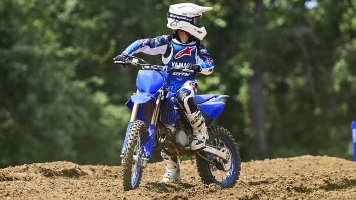 Yamaha YZ85 2026 med vožnjo po razgibanem motokros terenu z jasno vidnim vzmetenjem