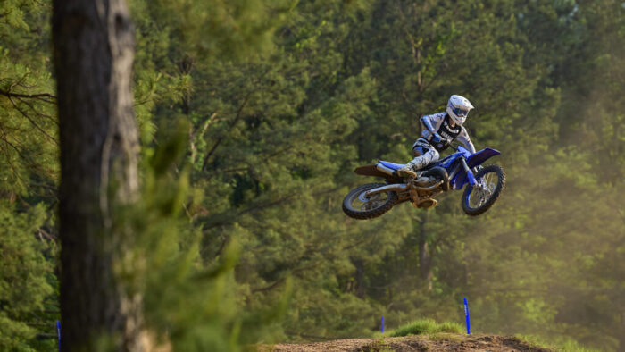Yamaha YZ125 v visokem skoku nad progo – maksimalna lahkotnost in dirkaška zmogljivost.